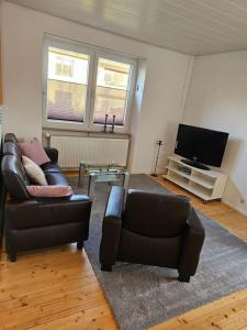 - un salon avec un canapé en cuir et une télévision dans l'établissement Große Ferienwohnung in Koblenz, à Coblence