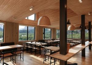 una sala da pranzo con tavoli, sedie e finestre di Explora en El Chalten a El Chalten