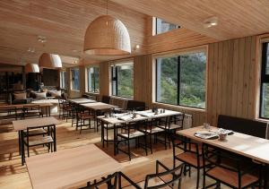 un restaurante con mesas, sillas y ventanas en Explora en El Chalten en El Chaltén