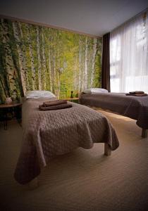 a bedroom with two beds and a mural of trees at Kempings Ozolkalns in Cēsis
