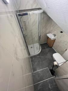 a small bathroom with a shower and a toilet at Krügers Hotel in Barsinghausen