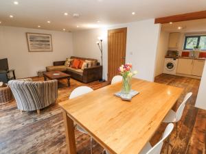 a living room with a wooden table with flowers on it at Grove Lodge in Penzance