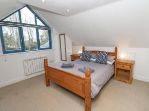 a bedroom with a wooden bed and a window at Grove Lodge in Penzance