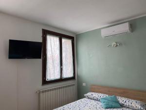 a bedroom with a bed and a window and a television at Il Tulipano in Trezzano Rosa