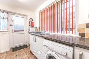 a kitchen with a sink and a dishwasher at Hindley Serviced Accommodation in Hindley
