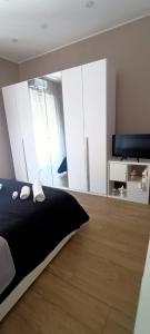 Schlafzimmer mit einem schwarzen Bett und weißen Schränken in der Unterkunft Tindaro Home in Catania