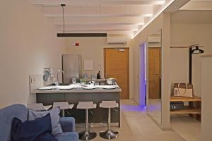 a kitchen and living room with a blue couch at Lamasu RioVerde - Lago di Garda in San Felice del Benaco
