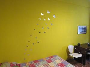 ein Schlafzimmer mit einer grünen Wand mit Schmetterlingen an der Wand in der Unterkunft Maddy House in Rom