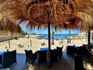 un tavolo e sedie sotto un ombrellone di paglia in spiaggia di La scelta giusta a Custonaci