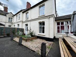 a white house with a garden in front of it at Private 7 bed wing of former farmhouse, edge of Exmoor, sleeps 16 in East Anstey