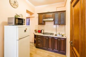a kitchen with a white refrigerator and a microwave at Romari Лесі Українки in Lviv
