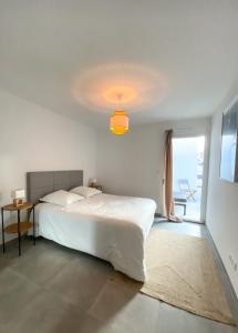een witte slaapkamer met een bed en een raam bij T3 30 dans résidence neuve près des plages in Saint-Cyr-sur-Mer