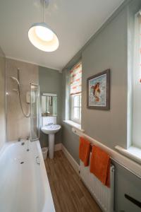 a bathroom with a white tub and a sink at Gatehouse, Bridge of Balgie, Glenlyon 