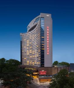 ein hohes Gebäude mit einem Schild an der Seite in der Unterkunft Crowne Plaza Hotel & Suites Landmark Shenzhen, an IHG Hotel - Nearby Luohu Border, Indoor heated swimming pool, Receive RMB100 SPA coupon upon check-in in Shenzhen