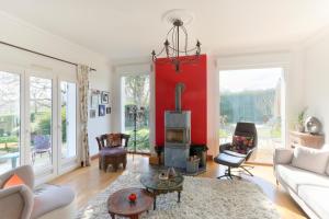 ein Wohnzimmer mit einer roten Wand und einem Kamin in der Unterkunft Belvedere de la Rance - Maison pour 6 avec jardin in Dinan