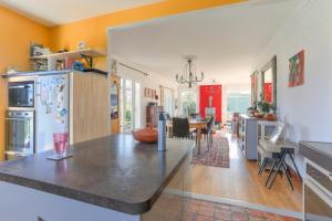 eine Küche und ein Wohnzimmer mit einem Tisch und einem Esszimmer in der Unterkunft Belvedere de la Rance - Maison pour 6 avec jardin in Dinan
