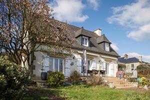 ein großes weißes Haus mit einem Dach in der Unterkunft Belvedere de la Rance - Maison pour 6 avec jardin in Dinan