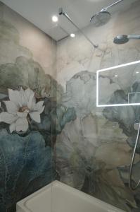 グダニスクにあるIRS ROYAL APARTMENTS Apartamenty IRS Neptun Parkの壁に花の壁画が施されたバスルーム