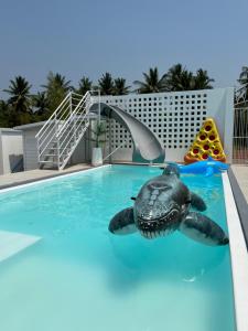 a fake turtle in a swimming pool at a resort at The PaVillu de Pool Villas in Samut Songkhram