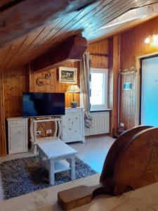 a living room with a tv and a table at Graziosa mansarda rustica - CIR VDA 0038 in Aosta