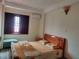 a bedroom with a bed and a window at Bống Homestay in Hai Phong