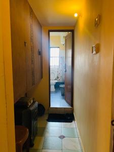 - un couloir menant à une salle de bains pourvue de toilettes dans l'établissement Raga Homestay 2BHK- A homely guesthouse experience, à Guwahati