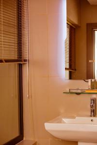 y baño con lavabo y ducha. en Hôtel les Vallons en Abiyán