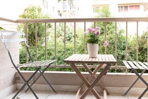 een tafel en stoelen op een balkon met een potplant bij Twins apartments - Concert Hall in Athene
