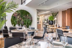 a restaurant with tables and chairs and a large flower arrangement at Salles Ciutat del Prat Barcelona Airport in El Prat de Llobregat