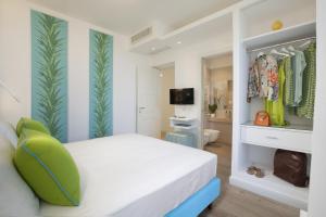ein Schlafzimmer mit einem weißen Bett und einem grünen Stuhl in der Unterkunft AMORE RENTALS - Resort Ravenna - The Villa in Massa Lubrense