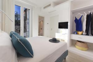 Schlafzimmer mit einem Bett mit blauen Kissen und einem TV in der Unterkunft AMORE RENTALS - Resort Ravenna - The Villa in Massa Lubrense