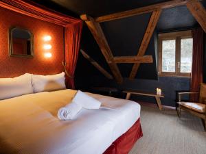 um quarto de hotel com uma cama e uma cadeira em Peanut Medieval Lodge em Saint-Ursanne