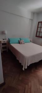 Cama grande en habitación con suelo de madera en Departamento Centro en San Salvador de Jujuy