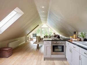 uma cozinha com um fogão e uma sala de jantar em Hollyhock Lodge em Buckinghamshire