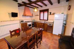 a kitchen with a wooden table and a refrigerator at Casas Rurales Trefacio in Trefacio