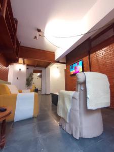 un salon avec un canapé et une télévision dans l'établissement Apartamento próximo aos principais pontos turísticos, à Águas de Lindóia