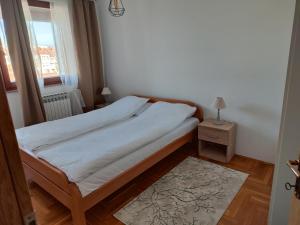 a small bedroom with a bed and a window at Apartman Dobrinja in Sarajevo
