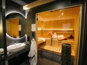 uma casa de banho com duas pessoas deitadas numa sauna em Projekt ŚWIT - domki z prywatną jacuzzi i sauną em Świnna