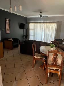 Amanzimtoti的住宿－L’Escalier Cabanas 510，客厅配有桌子和沙发