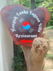 um sinal em forma de coração de madeira no lado de um edifício em Hanguk Lanka Lagoon Villa em Tangalle
