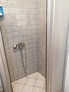 een badkamer met een douche met witte tegels bij Serhan Hotel in Gümbet