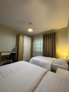 Habitación de hotel con 2 camas y escritorio en Brilant Apartament, en Tirana