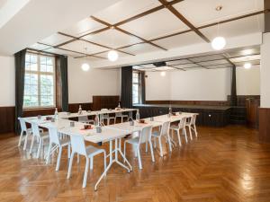 una sala conferenze con tavoli bianchi e sedie bianche di Peanut Medieval Lodge a Saint-Ursanne