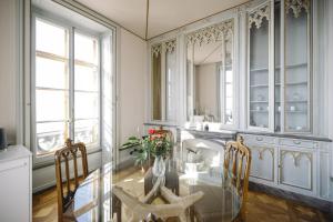 une salle à manger avec une table en verre et un miroir dans l'établissement Le Château de l'Aile, à Vevey