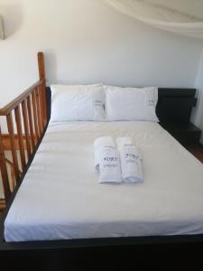 Una cama con dos almohadas blancas. en Olive Tree House II, 