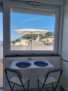 a table with two chairs and an umbrella at Romy Blu in Capri