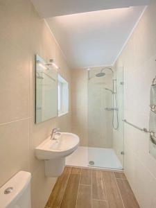 uma casa de banho branca com um lavatório e um chuveiro em Designer Furnished - Entire Apartment Sliema 1B by Solea em Sliema