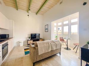 uma sala de estar com um sofá e uma mesa em Designer Furnished - Entire Apartment Sliema 1B by Solea em Sliema