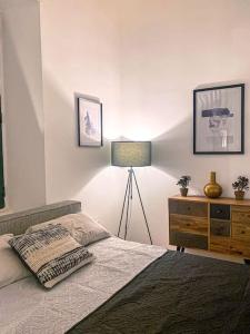 um quarto com uma cama, um candeeiro e uma cómoda em Designer Furnished - Entire Apartment Sliema 1B by Solea em Sliema
