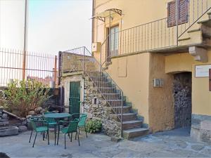 un patio con mesa y sillas junto a un edificio en La Maggiolina en Baveno